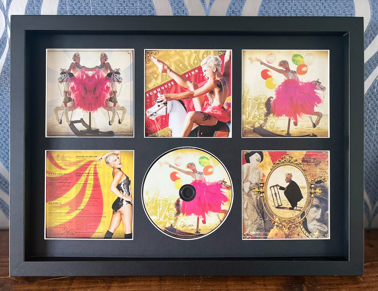 Framed CD with vintage-style album covers of a dancer and horse on a blue patterned background.