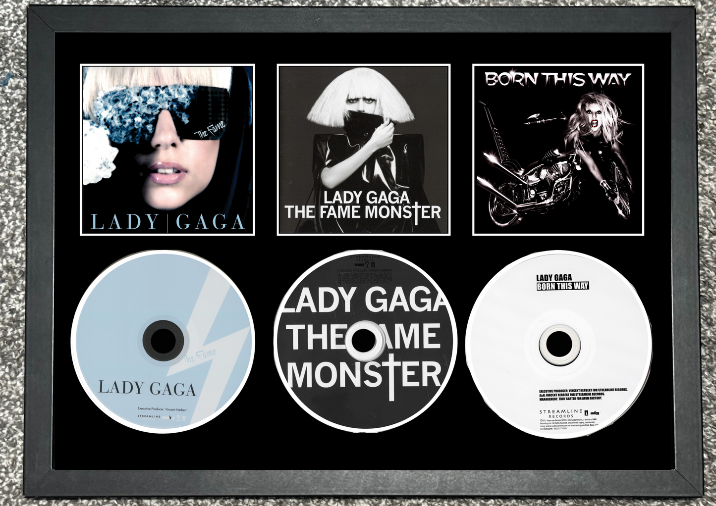 Framed Lady Gaga album and CD display with 'The Fame Monster' and 'Born This Way' albums.