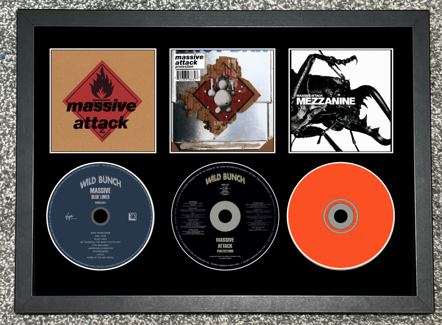 Framed album cover and CDs of Massive Attack's 'Mezzanine' and 'Mild Bunch'.