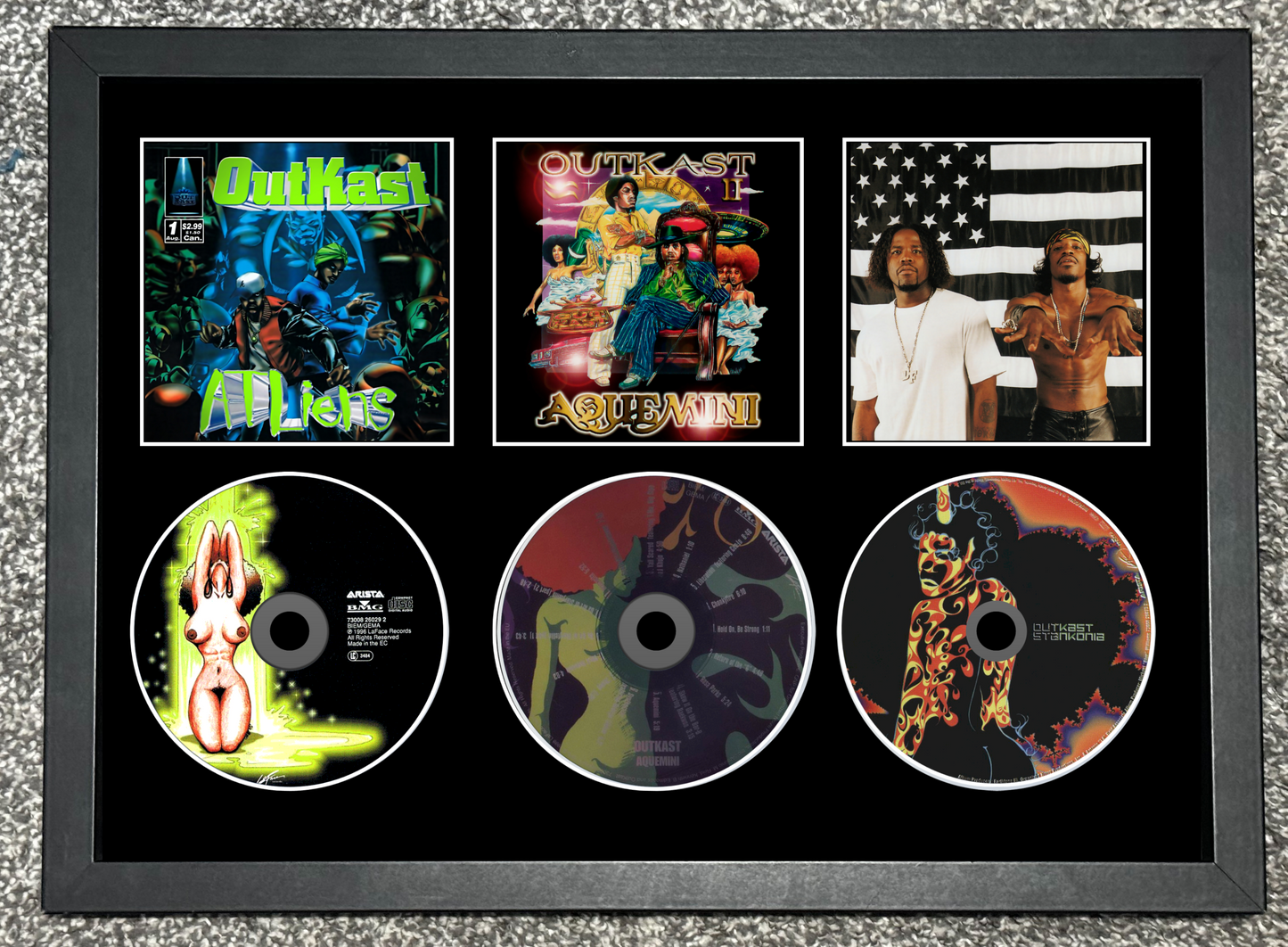 Framed display of Quikel's music albums and singles with cover art and disc images.