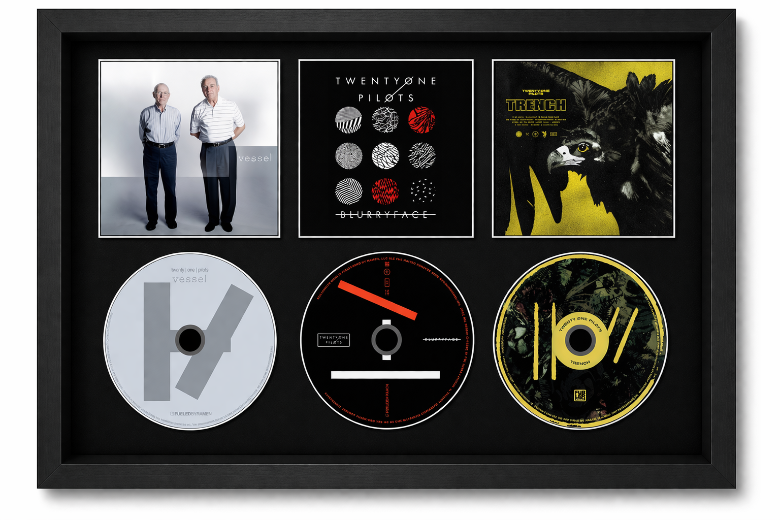 Framed display of TwentyOne Pilots music CDs and album covers.