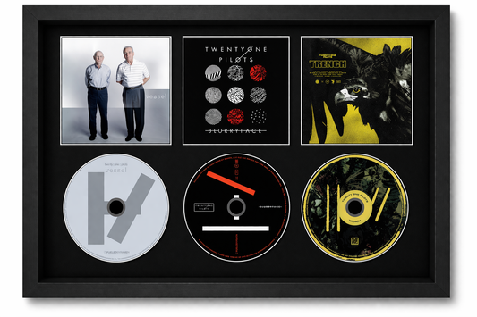 Framed display of TwentyOne Pilots music CDs and album covers.