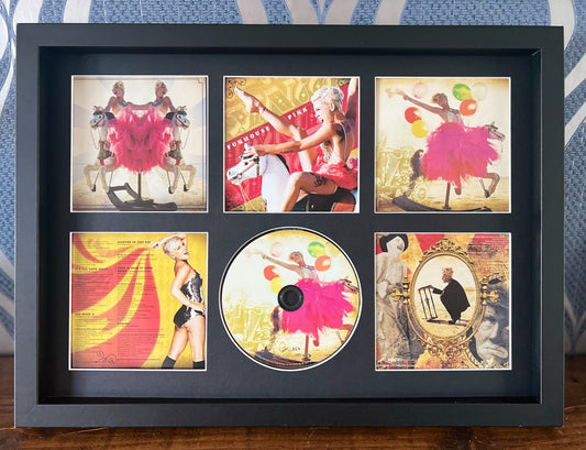 Framed CD with vintage-style album covers of a dancer and horse on a blue patterned background.