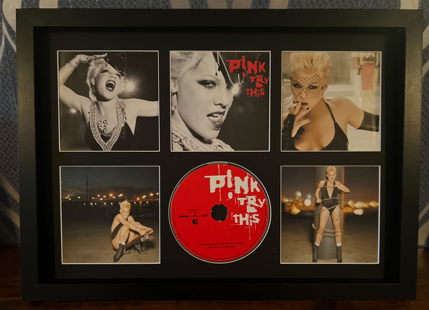 Framed album cover with 'Pink' featuring a red disc and black and white photos.