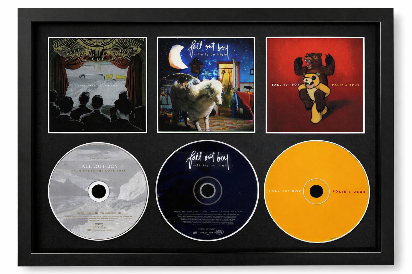 Framed music album collection with three CDs and cover images on a white background