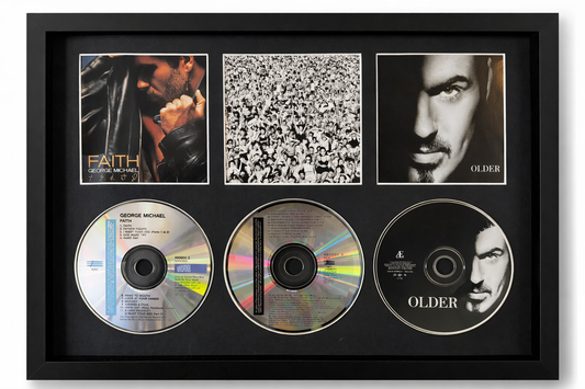 Framed CD display with album covers and CDs featuring George Michael.