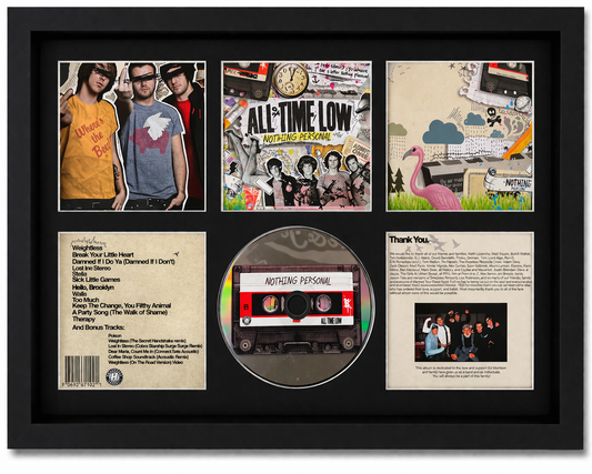 Framed display of a music album cover with a cassette tape and additional images.