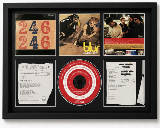 Framed album cover and related items of the band Blur, including a CD and lyrics.