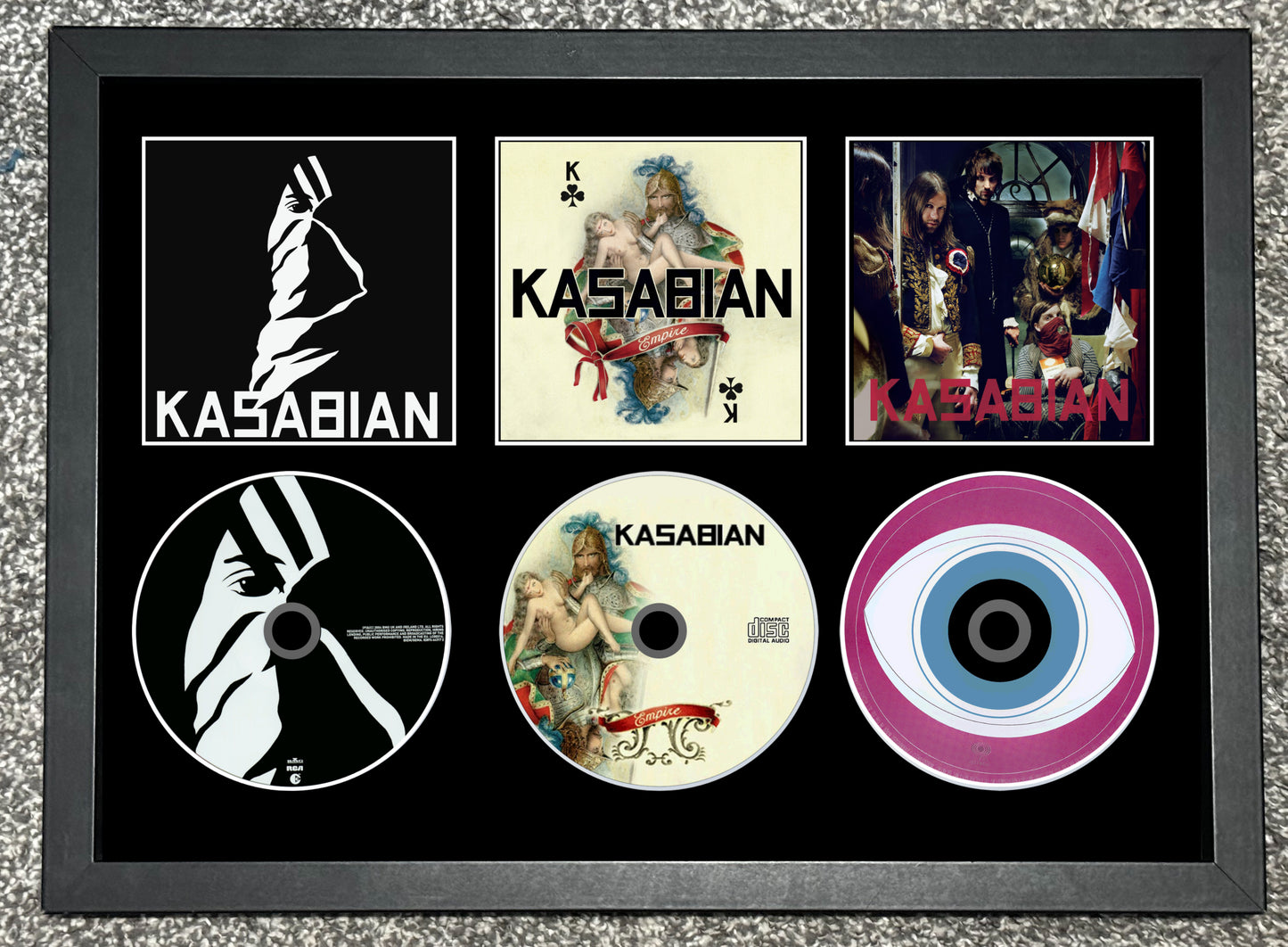 Framed collage of Kasabian album covers and logo on a textured surface