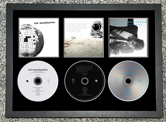 Framed Iced Soundsystem CDs with album covers on a textured surface