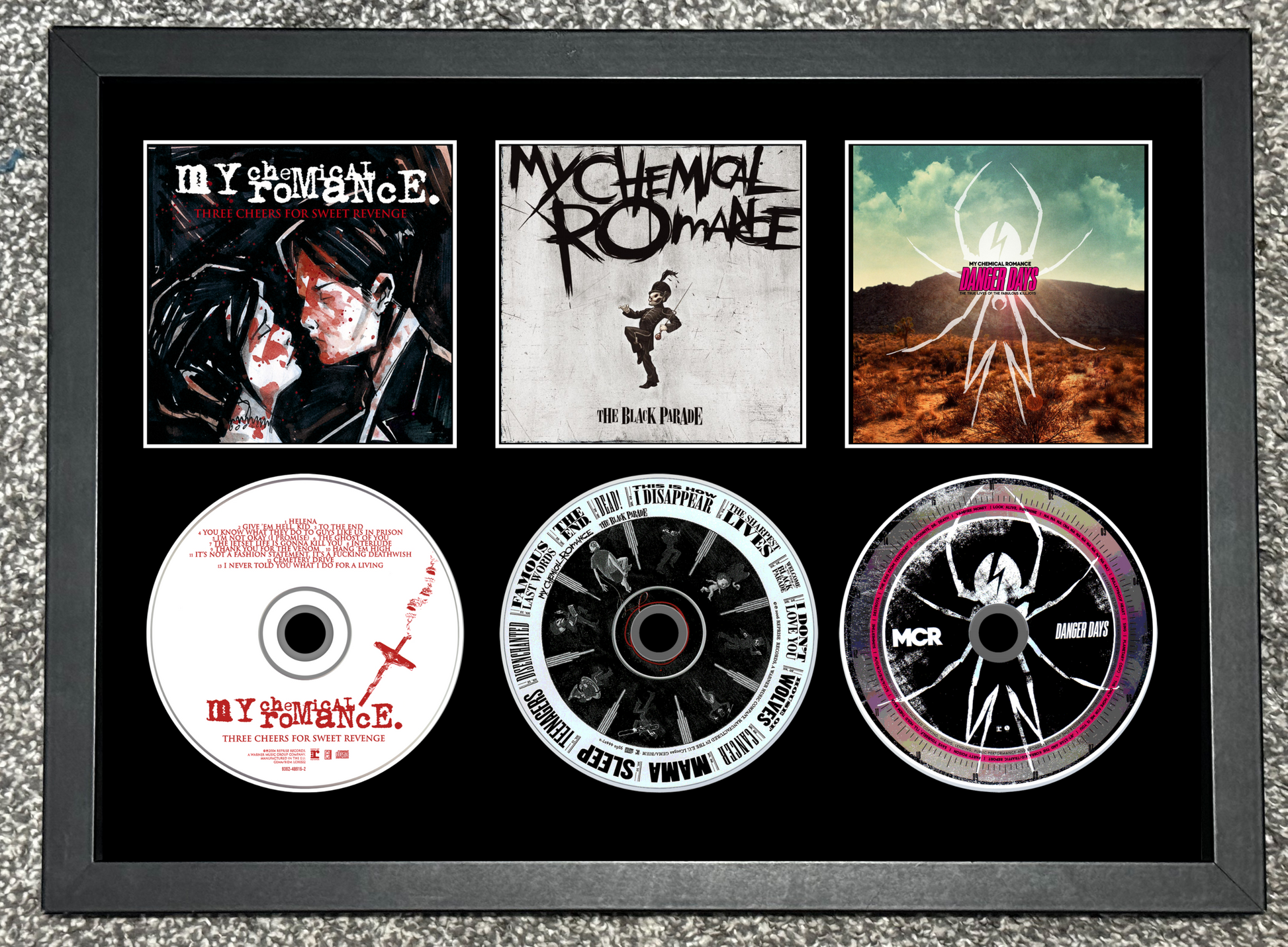 Framed album cover and CDs of My Chemical Romance on a textured surface