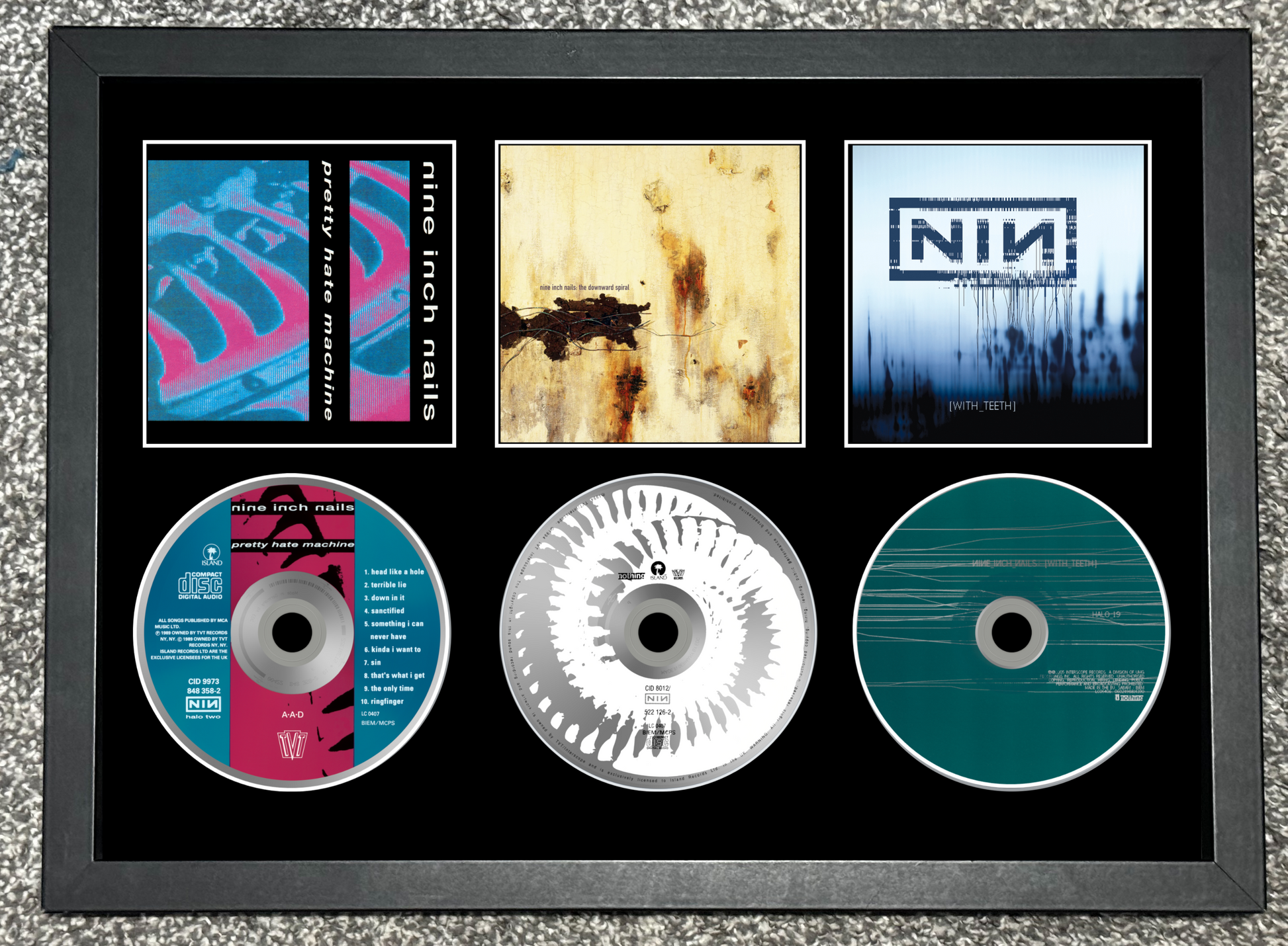 Framed Nine Inch Nails music collection with album covers and CDs.