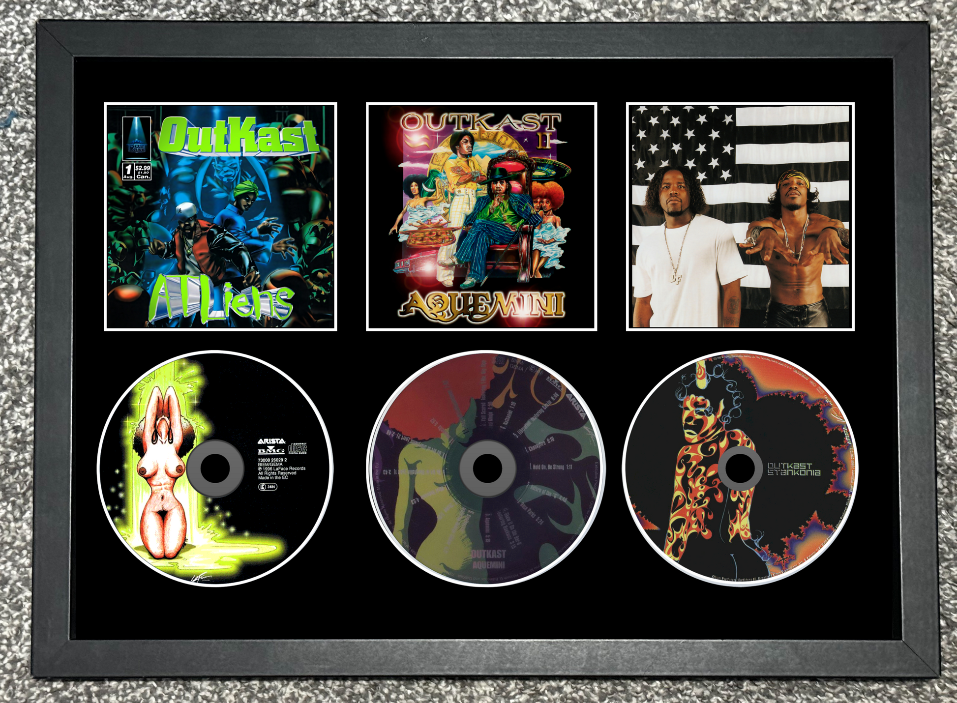Framed display of Quikel's music albums and singles with cover art and disc images.