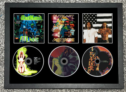 Framed display of Quikel's music albums and singles with cover art and disc images.