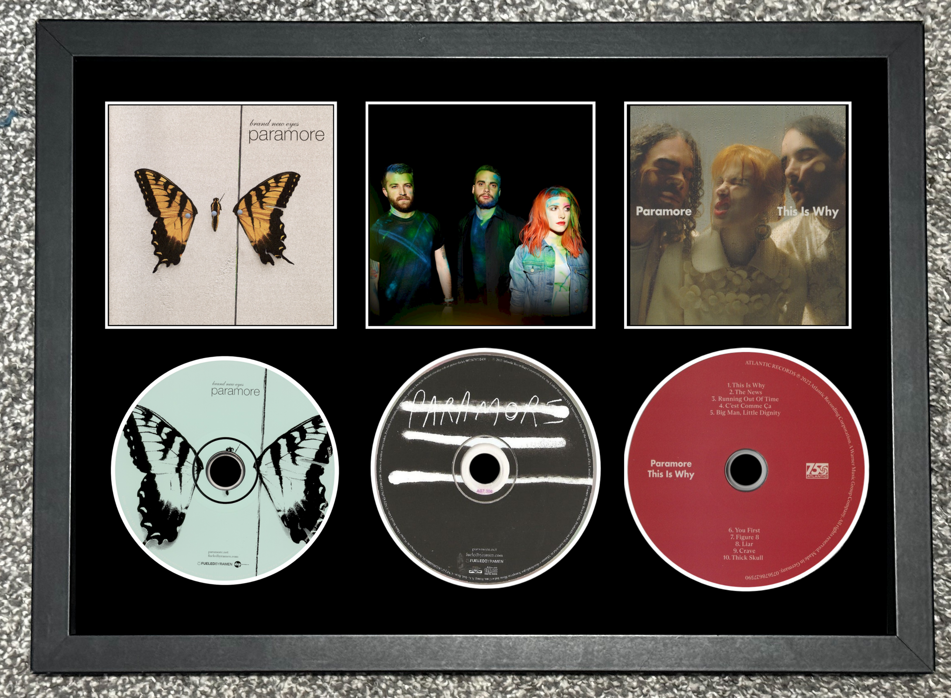 Framed Paramore music collection with album covers and CDs.