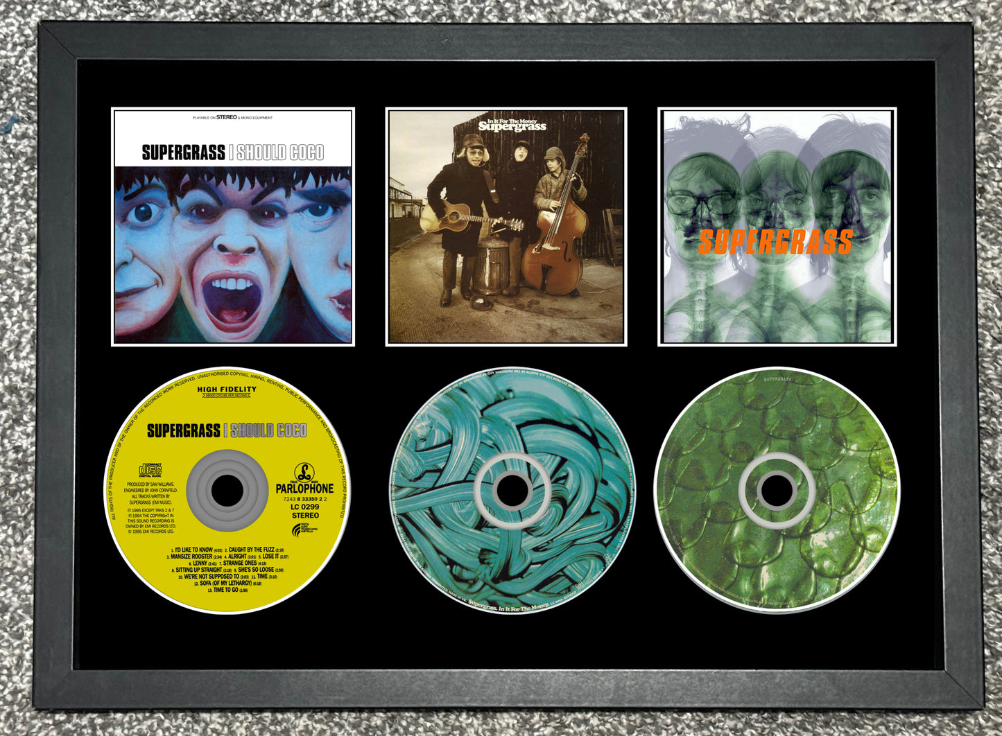 Framed display of Supercell music album covers and CDs.