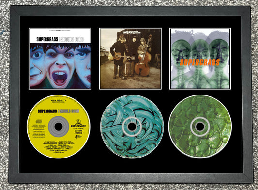 Framed display of Supercell music album covers and CDs.