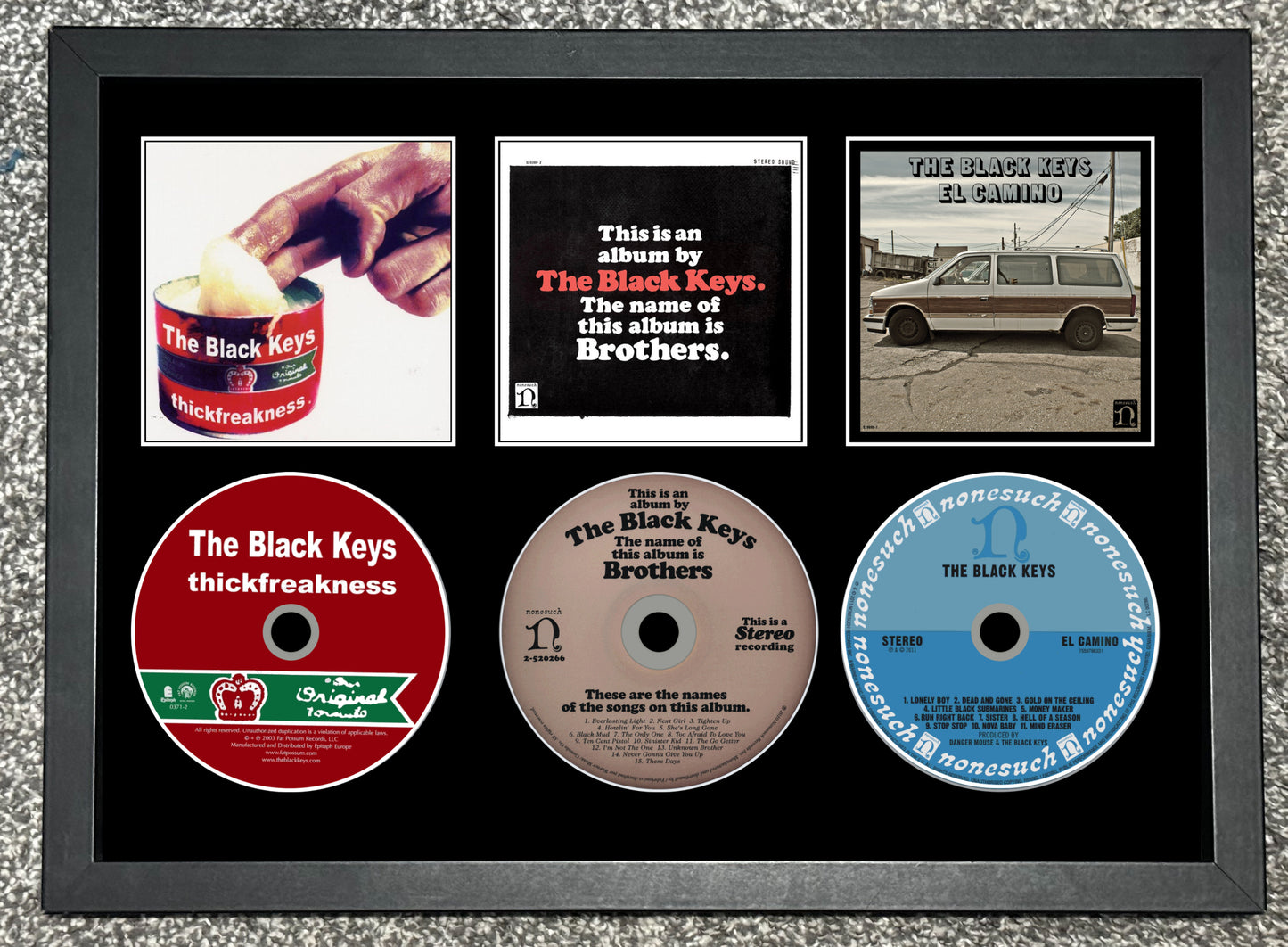 Framed collage of The Black Keys music album covers and CDs.