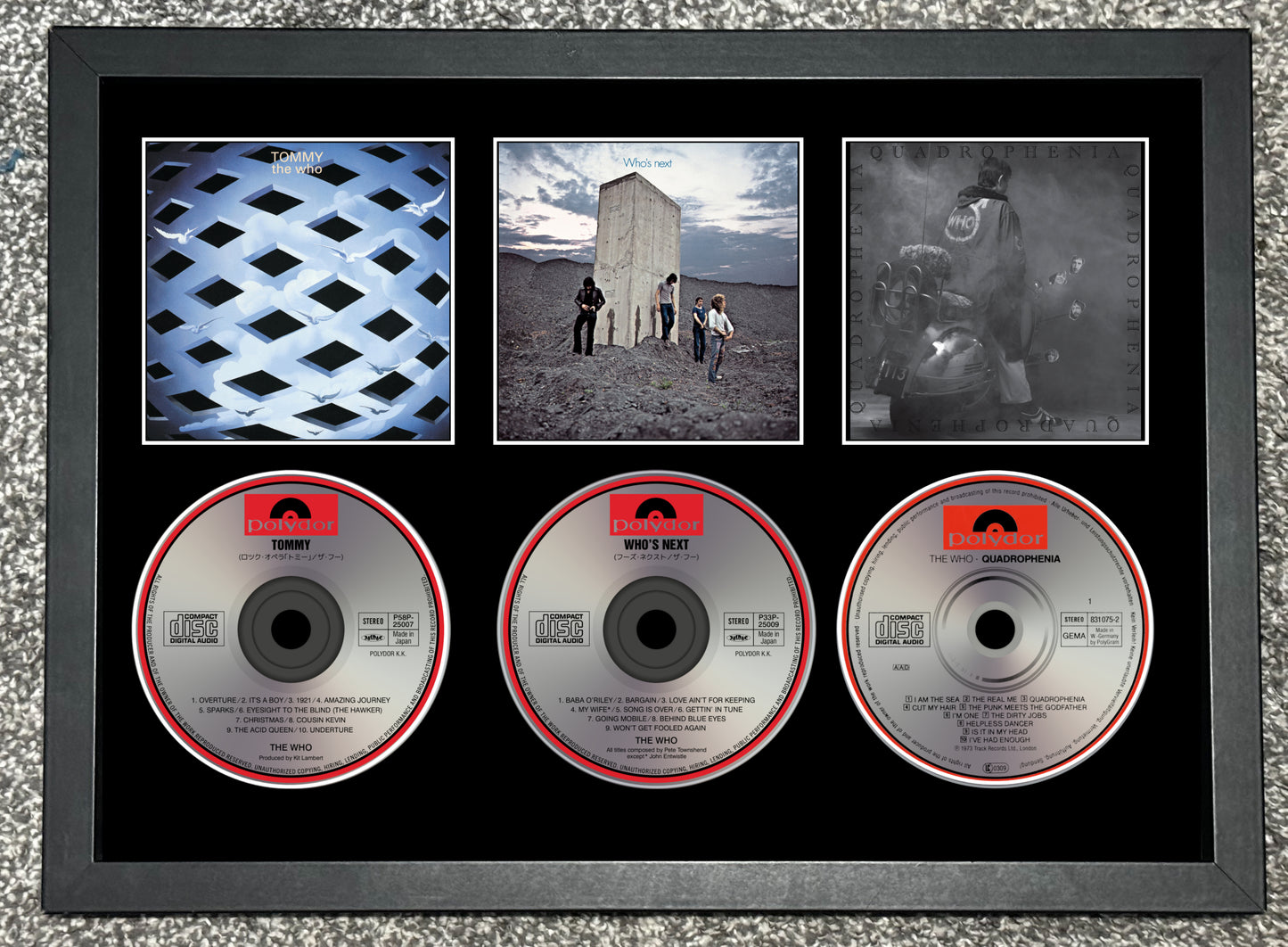 Framed CD collection with album covers and CDs on a textured surface