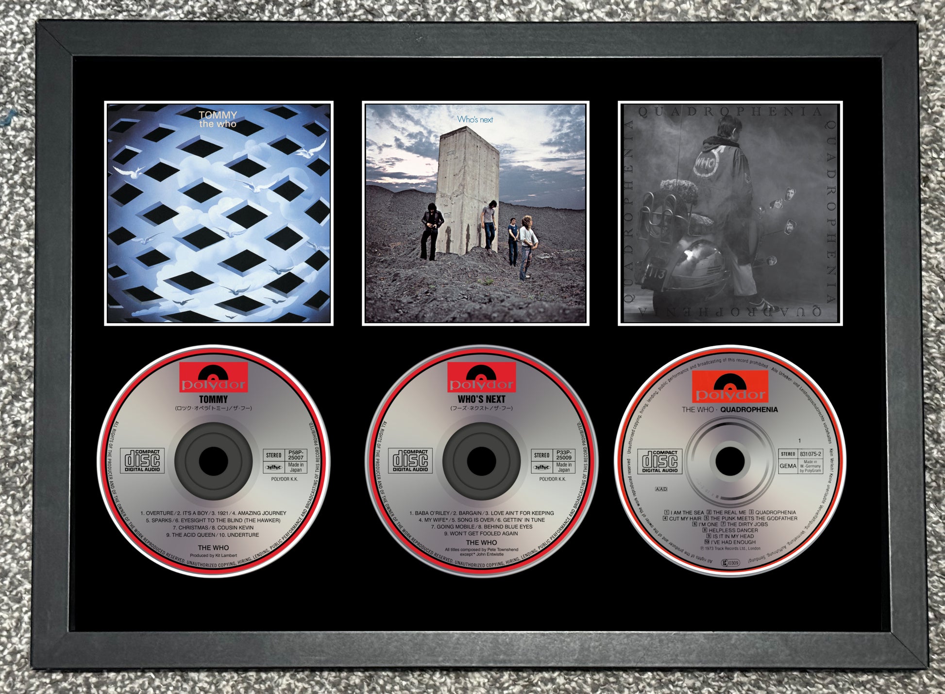 Framed CD collection with album covers and CDs on a textured surface